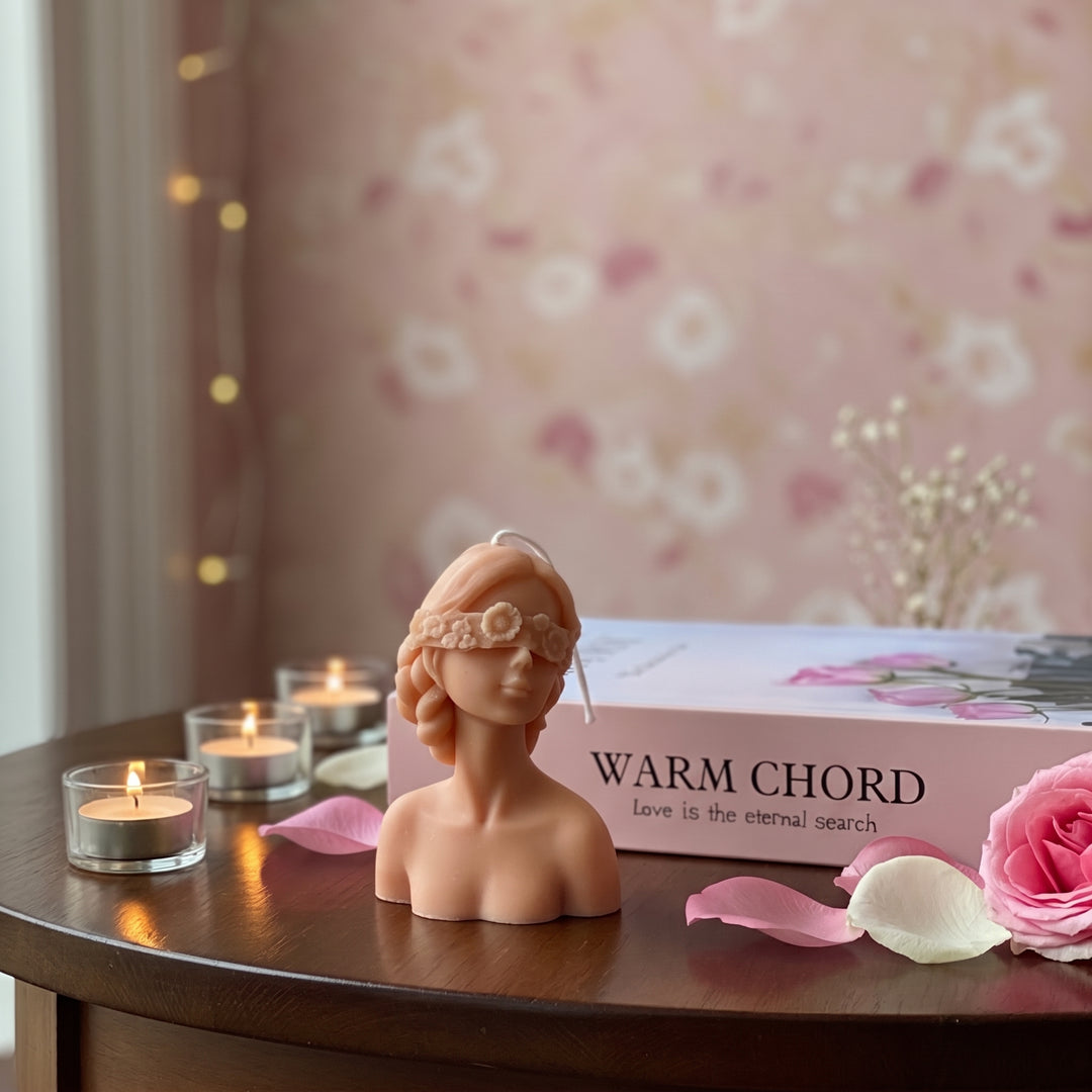 A pink and beige scented candle shaped like a woman&