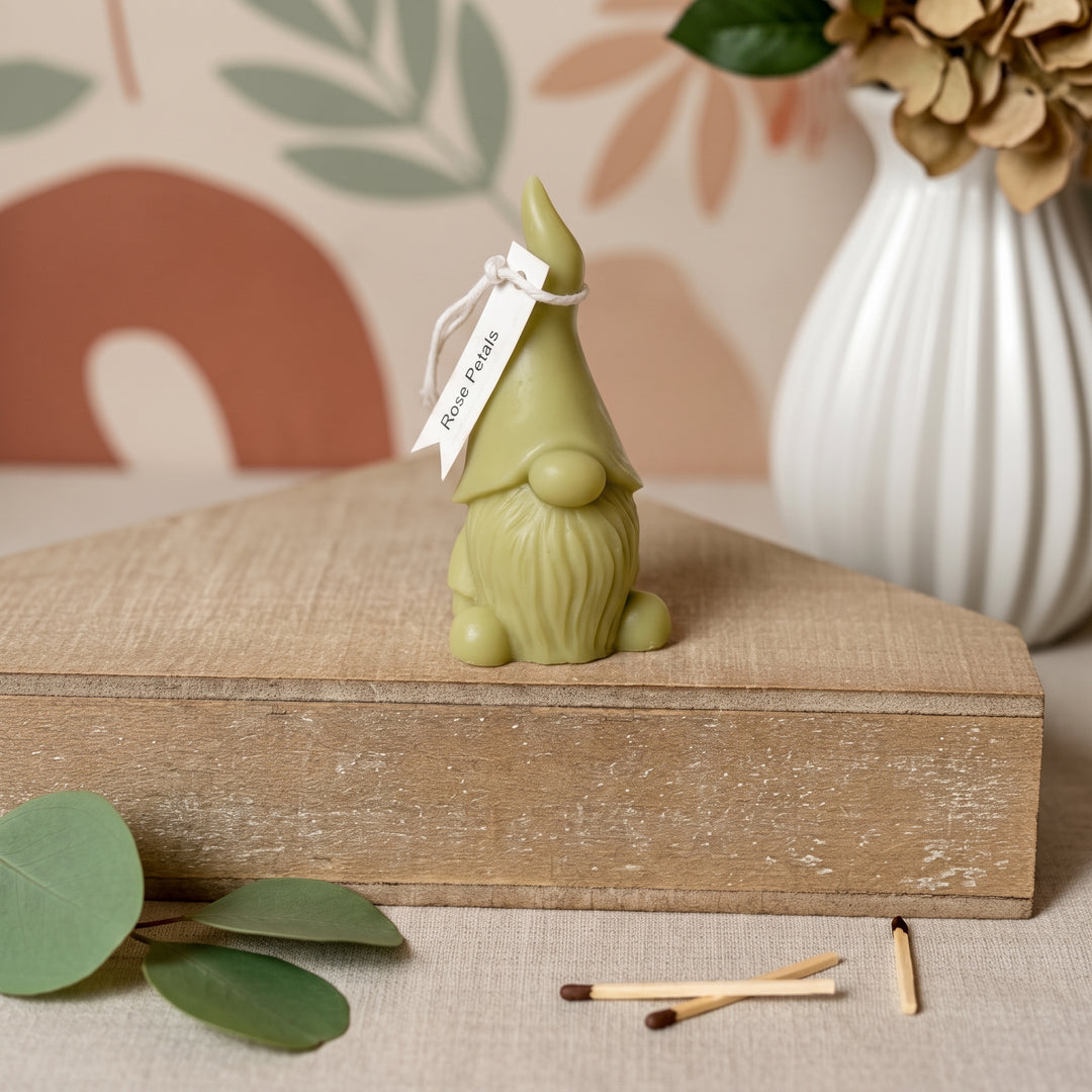 A small olive green gnome figurine with a white paper tag reading &