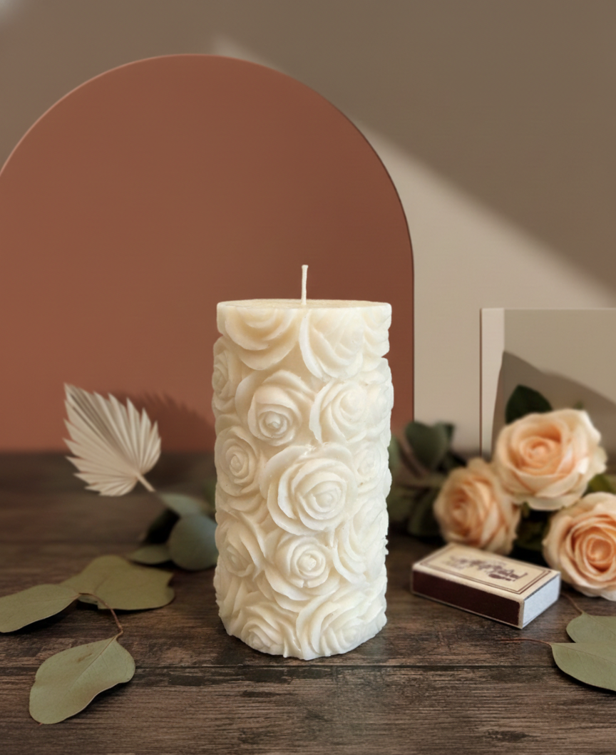 Handmade botanical rose soy wax candle infused with real pink flower petals on a rustic wooden table.