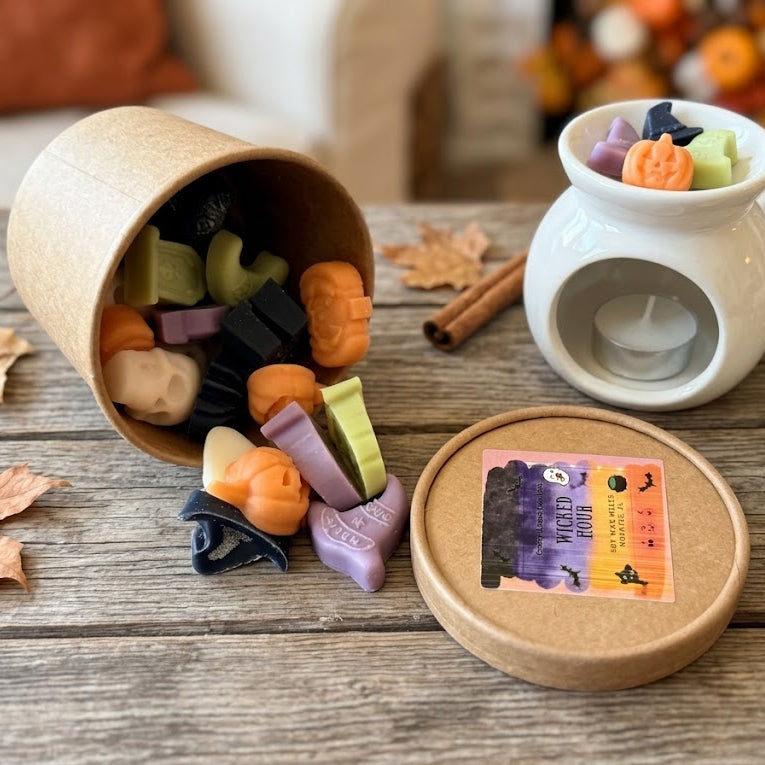 Colorful Halloween wax melts spilling from the Wicked Hour container beside a white melter
