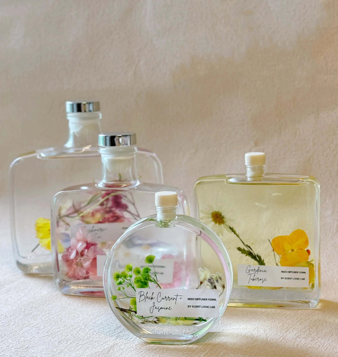 Handcrafted botanical reed diffusers in glass bottles with real dried flowers for home decor and unique gift ideas.